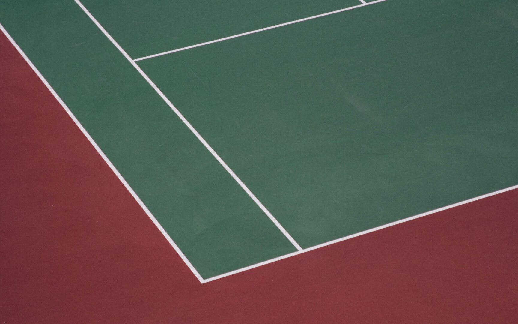 A tennis court with two different colors of green and white.