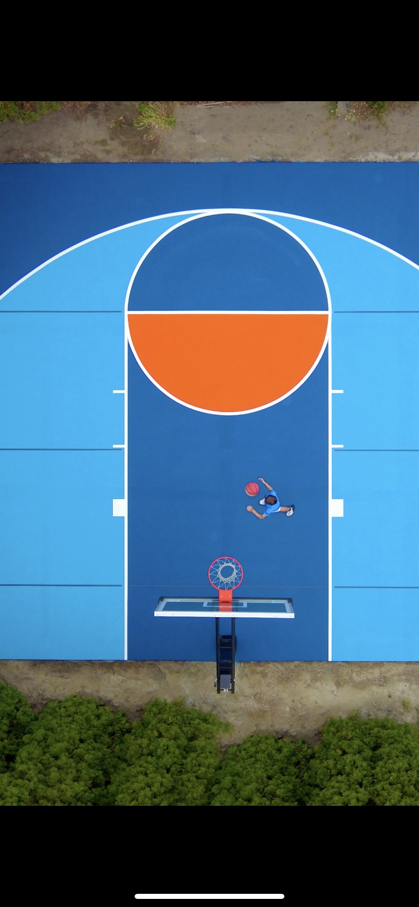 A basketball court with a hoop and a ball.