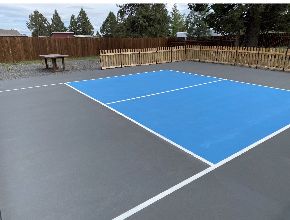 A tennis court with blue and white lines.