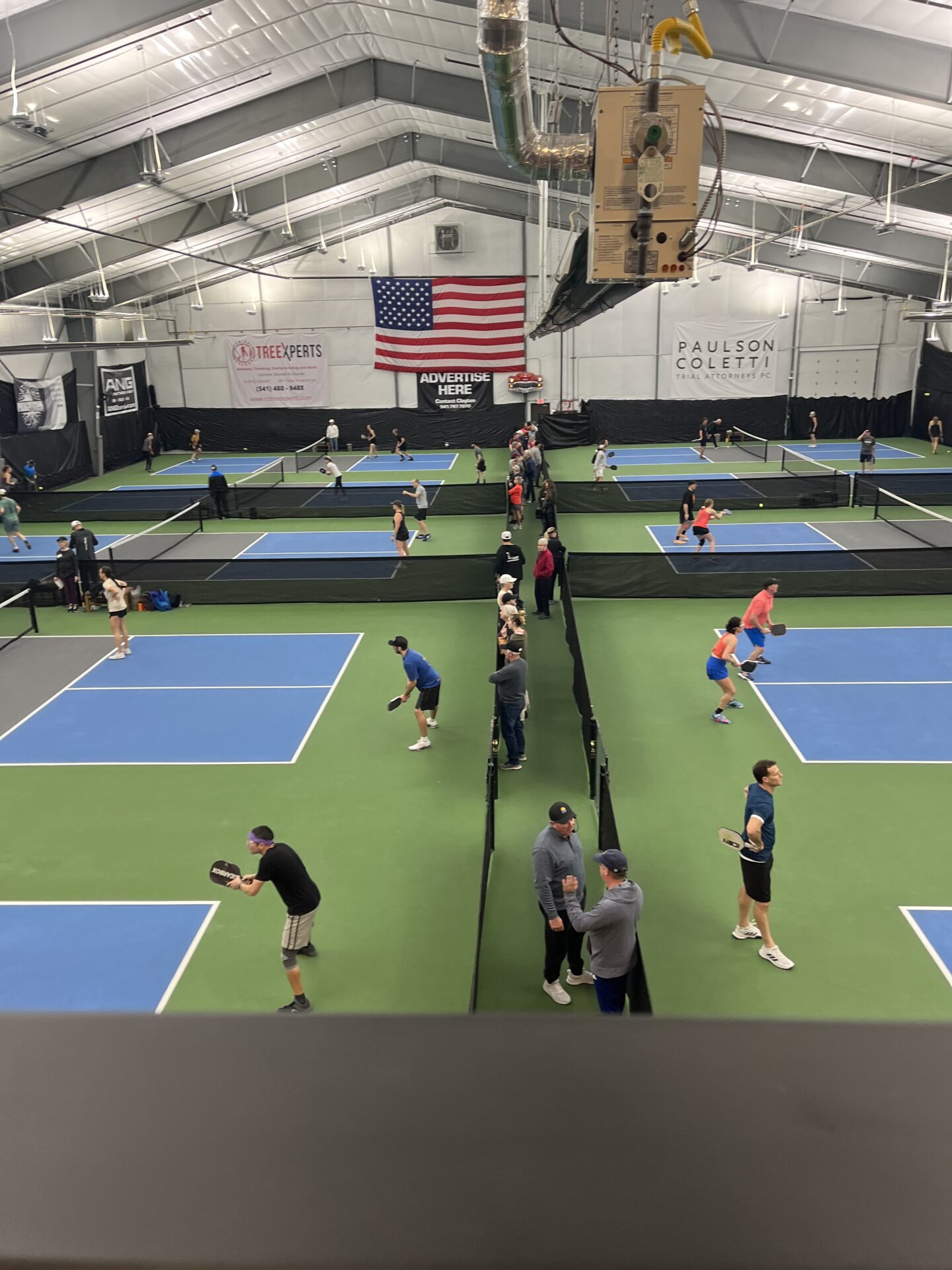 A group of people playing tennis in an indoor court.