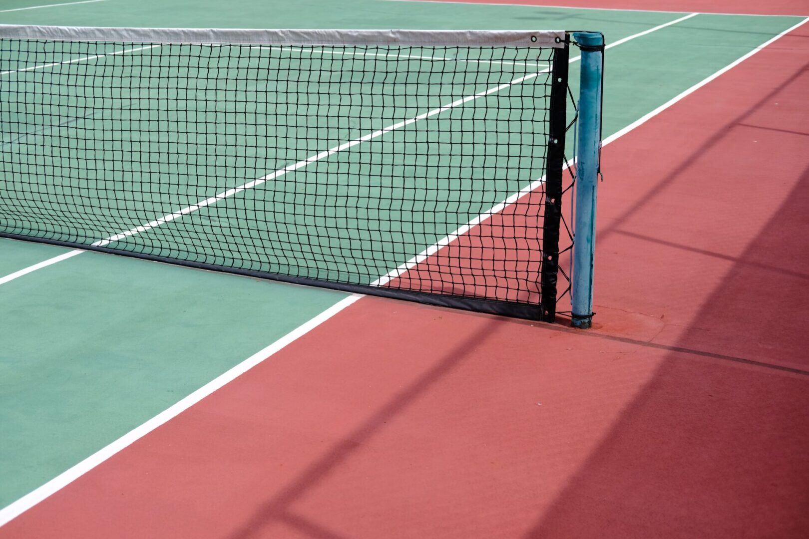 A tennis court with a net on the side.